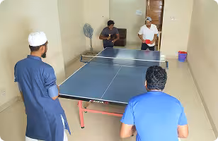 Jouleslabs team members playing table tennis during a work break to recharge for high-productivity AI development services and production-grade SaaS engineering.